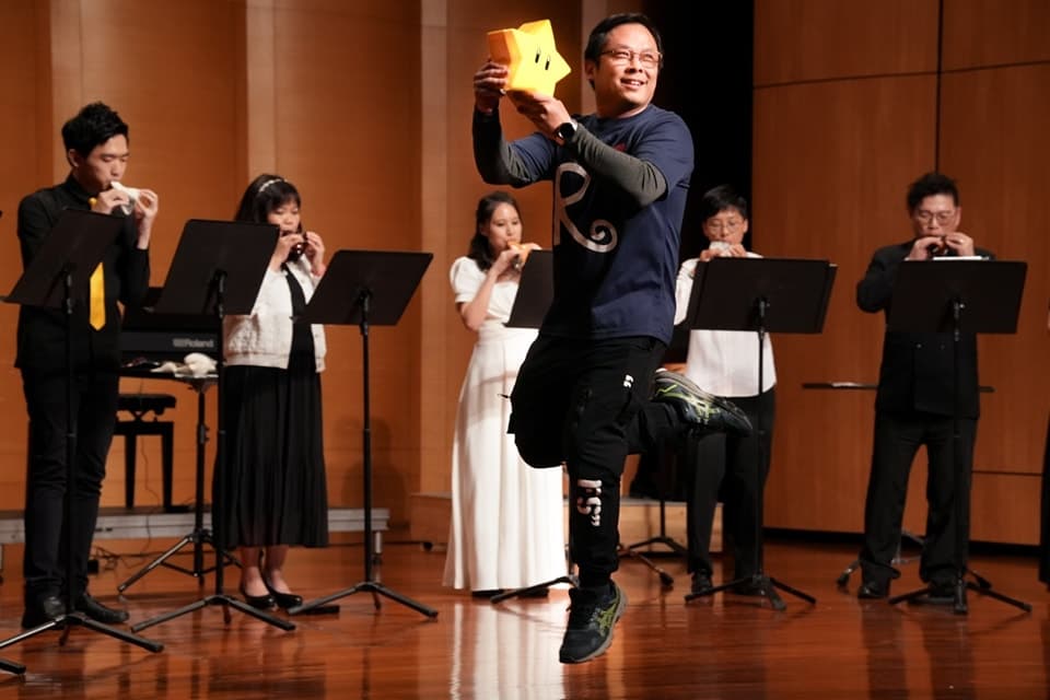 「オカリナ Do Re Mi」で、メンバーの演奏を背景に星の小道具を持って跳ぶ指揮者